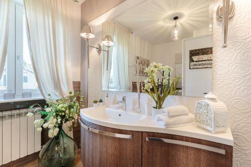 een badkamer met een wastafel en een spiegel bij VILLA PEMOLA a Luxury Farmhouse with Garden and bikes in Lucca Town in Capannori