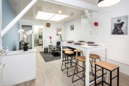 - une cuisine et un salon avec un comptoir et des tabourets dans l'établissement Le saint honoré, à Amiens