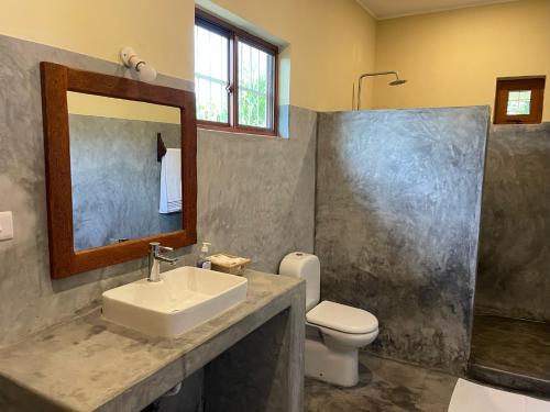 a bathroom with a sink and a toilet and a mirror at Diana Place in Paje