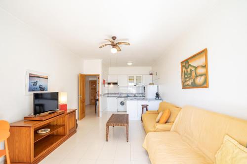 a living room with a couch and a tv and a kitchen at Apartamento Sra da Rocha by Umbral in Porches