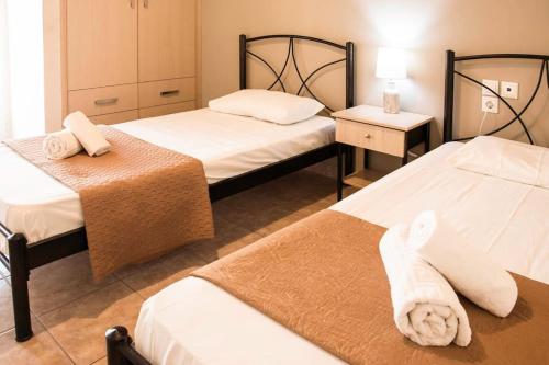 a hotel room with two beds with towels on them at Margaret Apartments in Lefkimmi