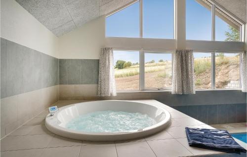a large bath tub in a room with windows at Gorgeous Home In Vejby With Indoor Swimming Pool in Vejby