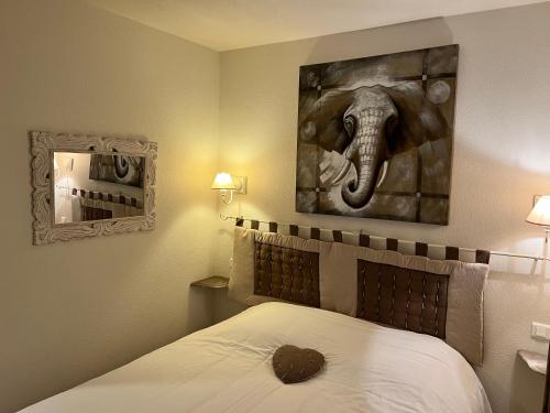 1 dormitorio con 1 cama con una pintura de elefante en la pared en Mazet de Malo en Saint-Rémy-de-Provence