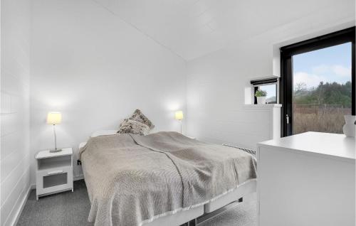 a white bedroom with a bed and a window at Relax in Ejstrup