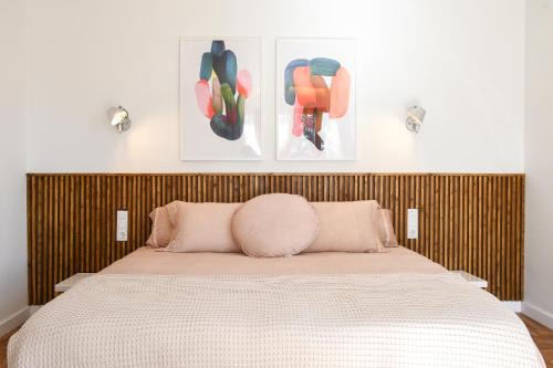 a bedroom with a bed with two pictures on the wall at Casa Maui in Banyoles