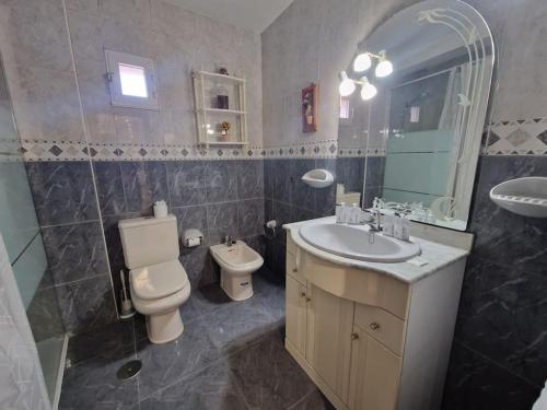 y baño con lavabo, aseo y espejo. en 168A Apartamento en el Natahoyo , Gijón en Gijón