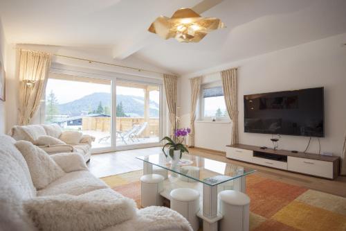 a living room with a couch and a tv and a glass table at Haus Eibl in Seefeld in Tirol