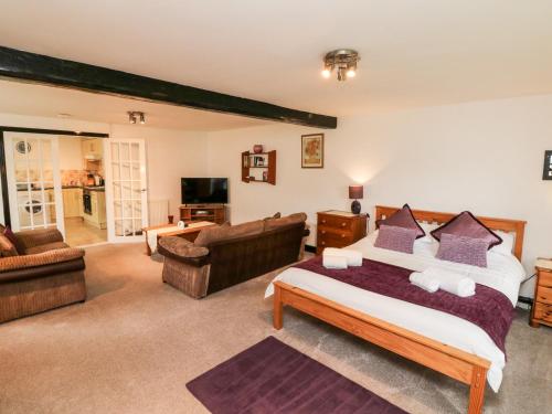 a bedroom with a bed and a living room at Priory House Cottage in Barnstaple