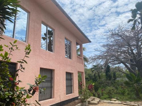 różowy budynek z oknami na boku w obiekcie Tradewinds Lodge w mieście Diani Beach