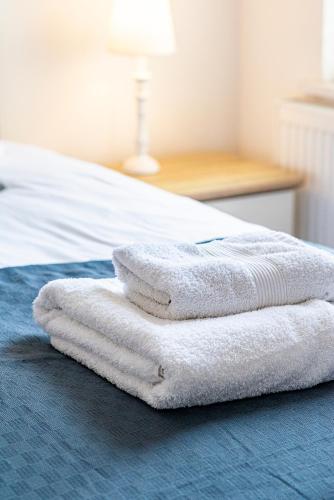 a pile of towels sitting on top of a bed at Greyfriars in Clacton-on-Sea