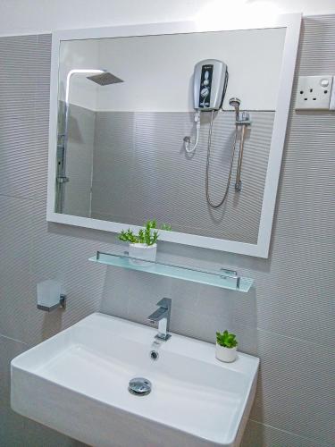 a bathroom sink with a shower and a mirror at Crystal Resort in Badulla
