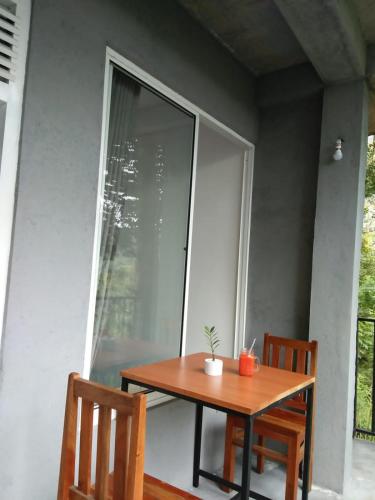 a table and two chairs on a porch with a window at Crystal Resort in Badulla