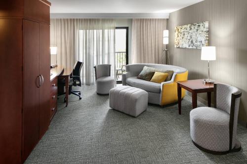 a hotel room with a couch and a chair and a desk at Courtyard Bethlehem Lehigh Valley/I-78 in Bethlehem