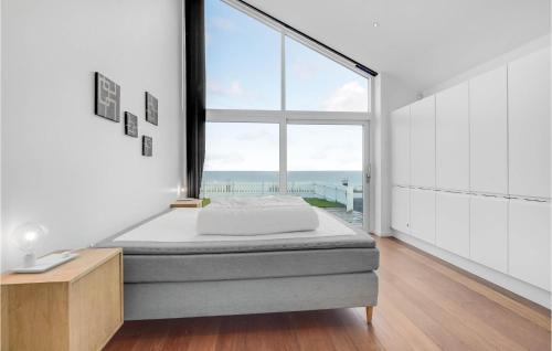 um quarto com uma cama e uma grande janela em Amazing Home In Strby With House Sea View em Strøby