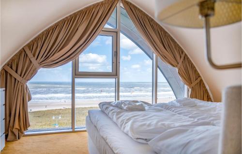 a bedroom with a bed and a large window with the beach at Appartement Shrimp in Egmond aan Zee