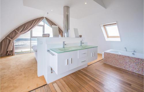 a white bathroom with two sinks and a bath tub at Appartement Shrimp in Egmond aan Zee