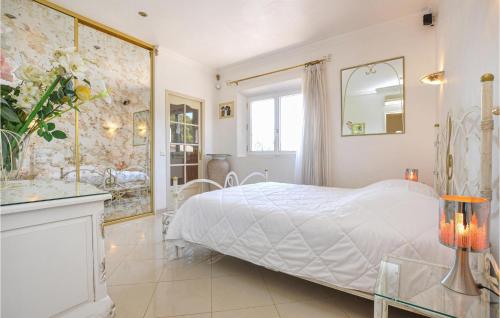 レ・ザドレ・ド・レステレルにあるLa Cle De Solの白いベッドルーム(ベッド1台、鏡付)