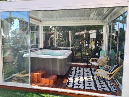 a screened in hot tub on a patio with two chairs at B&B Val D'azur in Carqueiranne
