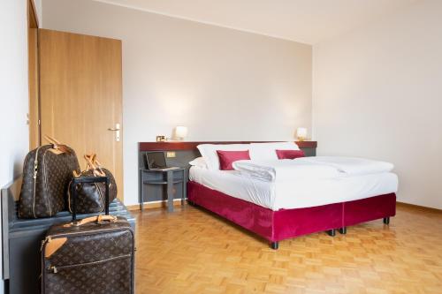 una habitación de hotel con una cama y una maleta en Hotel Pittini, en Gemona del Friuli