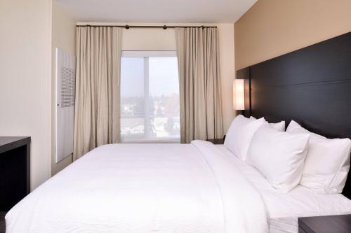 ein großes weißes Bett in einem Hotelzimmer mit Fenster in der Unterkunft Residence Inn by Marriott Bakersfield West in Bakersfield