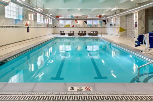 a large indoor swimming pool with blue water at Aloft Buffalo Downtown in Buffalo