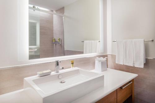 een witte badkamer met een wastafel en een spiegel bij Element Chelmsford in Chelmsford