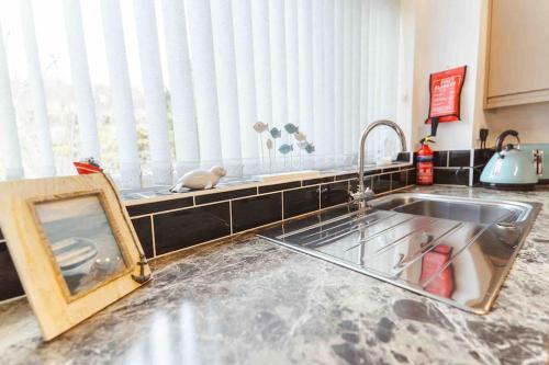a kitchen counter with a sink and a window at Watersedge Retreat, views, sunsets, dogs welcome in Sandside