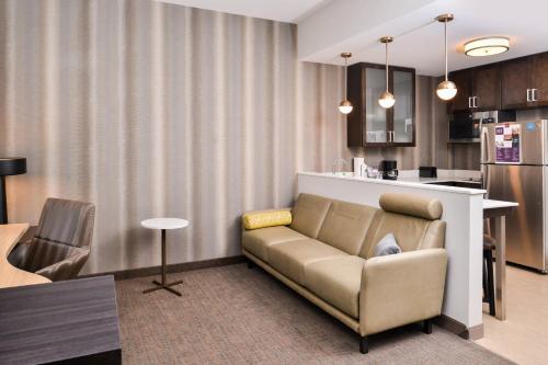 a living room with a couch and a kitchen at Residence Inn by Marriott Charlotte Northlake in Charlotte