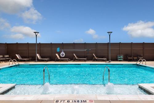 a large swimming pool with chairs and aermottermott at Residence Inn by Marriott Charlotte Northlake in Charlotte