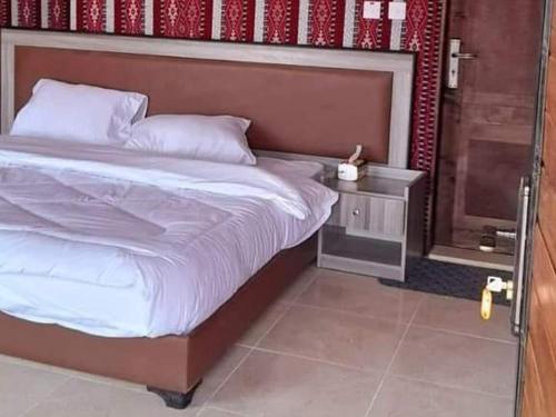 una camera con un grande letto con testiera in legno di Wadi Rum nature a Wadi Rum