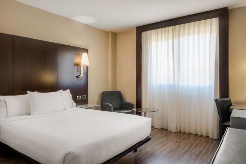 a hotel room with a bed and a desk and chair at AC Hotel Elda by Marriott in Elda