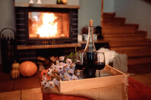 a crate of wine glasses and flowers on a table with a fireplace at Domki RADAWA na Kliszówce in Radawa