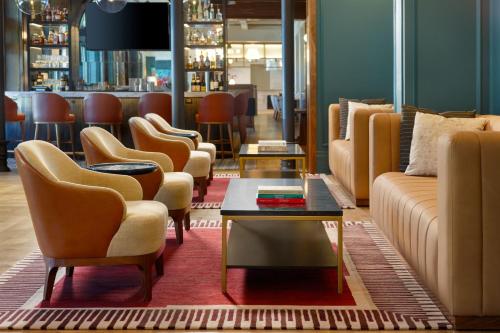 a lobby with couches and chairs and a bar at The Alamite, Tuscaloosa, a Tribute Portfolio Hotel in Tuscaloosa