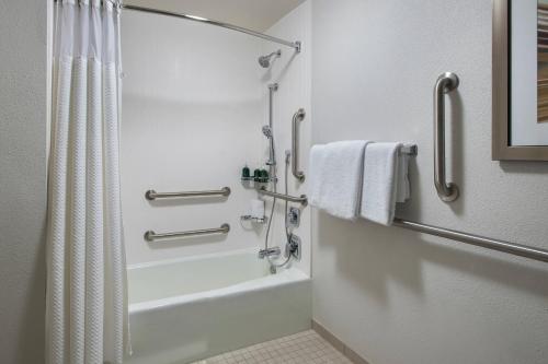 y baño con ducha, bañera y cortina de ducha. en Courtyard by Marriott Lincroft Red Bank, en Red Bank