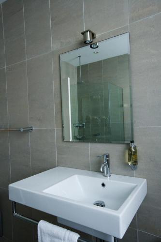 a bathroom with a white sink and a mirror at Dive Hotel in Sydney
