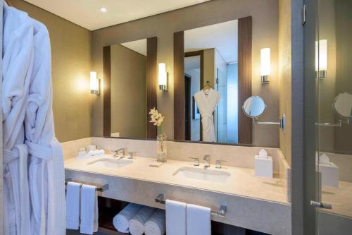 a bathroom with two sinks and a large mirror at Courtyard by Marriott Bogota Airport in Bogotá