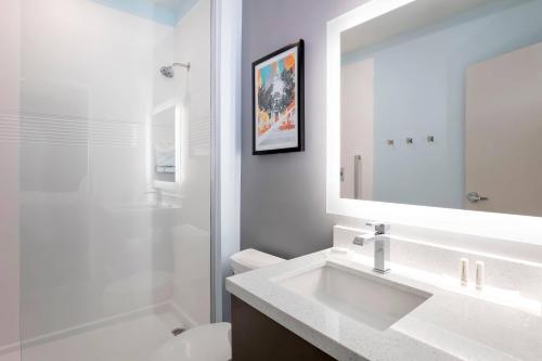 een witte badkamer met een wastafel en een spiegel bij TownePlace Suites Amarillo West/Medical Center in Amarillo