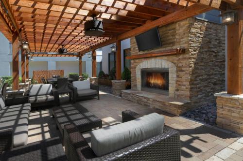 an outdoor patio with a fireplace and a tv at Courtyard by Marriott Dallas DFW Airport North/Irving in Irving