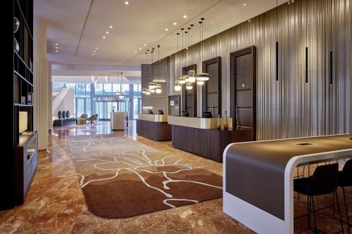 a lobby with a reception desk and a hair salon at Basel Marriott Hotel in Basel