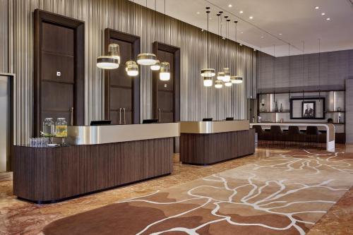 a hotel lobby with a reception desk and chandeliers at Basel Marriott Hotel in Basel