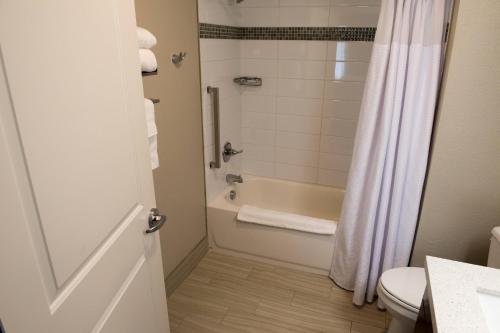 y baño con ducha, bañera y aseo. en TownePlace Suites by Marriott Battle Creek en Battle Creek