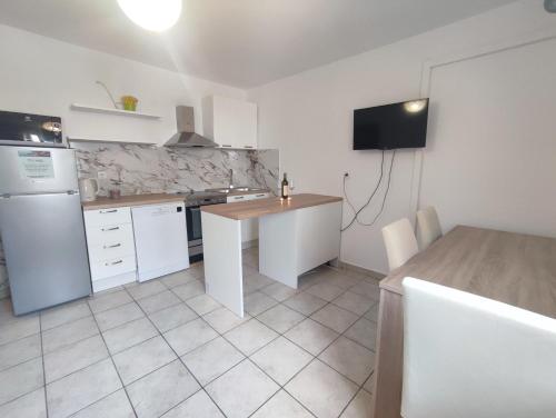 a kitchen with white appliances and a table in it at Apartments Laus in Zavalatica