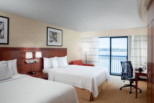 a hotel room with two beds and a desk and a window at Courtyard Richland Columbia Point in Richland