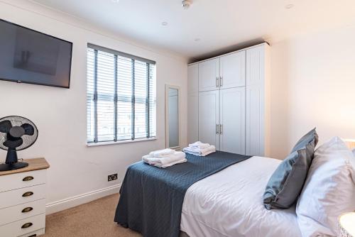 a bedroom with a bed and a flat screen tv at Greyfriars in Clacton-on-Sea