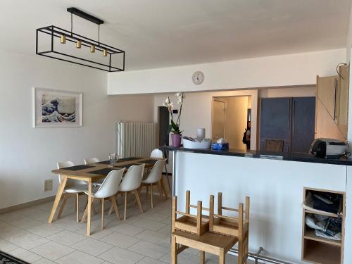 uma cozinha e sala de jantar com mesa e cadeiras em Appartement vue sur mer - Splendide localisation! em Koksijde
