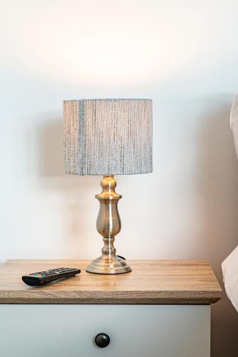 a lamp on a table with a remote control at Greyfriars in Clacton-on-Sea
