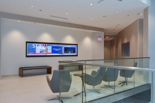 a glass table with chairs and a television on a wall at SpringHill Suites by Marriott Charlotte City Center in Charlotte