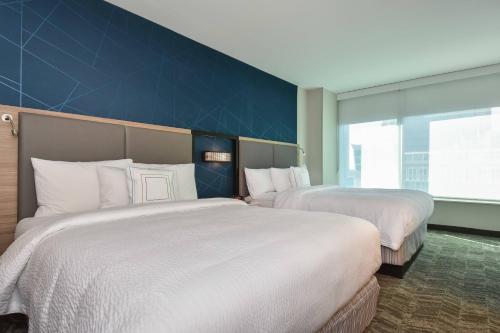 a hotel room with two beds and a blue wall at SpringHill Suites by Marriott Charlotte City Center in Charlotte