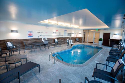 een groot zwembad in een hotelkamer met tafels en stoelen bij Fairfield Inn & Suites by Marriott Detroit Lakes in Detroit Lakes