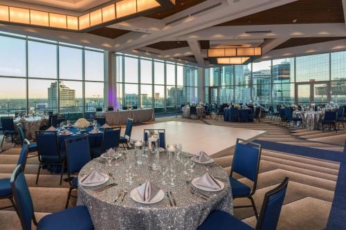 uma sala de jantar com mesas e cadeiras e janelas de vidro em SpringHill Suites by Marriott Charlotte City Center em Charlotte
